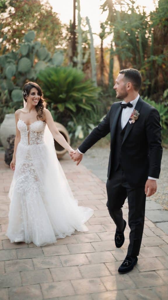 Sposi felici in abiti da matrimonio, atmosfera romantica e naturale con luci calde, ambientazione all'aperto, servizi di wedding planning by ChiaraB Events, matrimonio elegante e intimo.