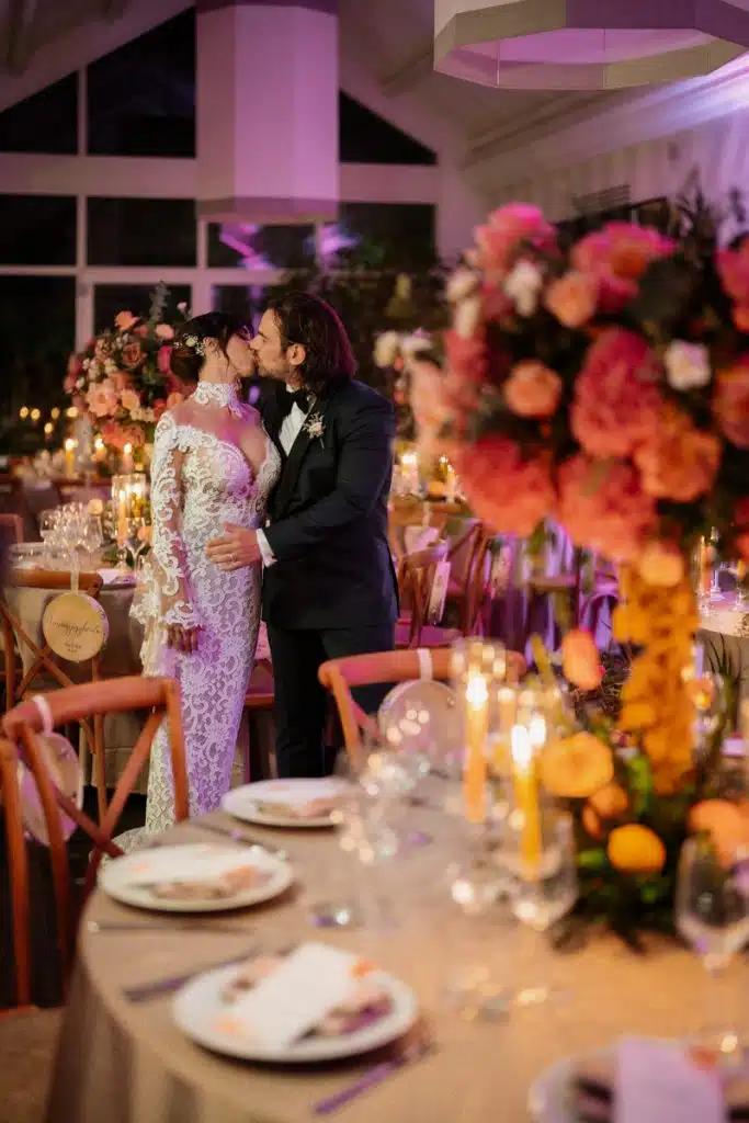 Bacio tra sposi durante un matrimonio romantico con decorazioni floreali di ChiaraB Events, rinomato wedding planner in Italia.