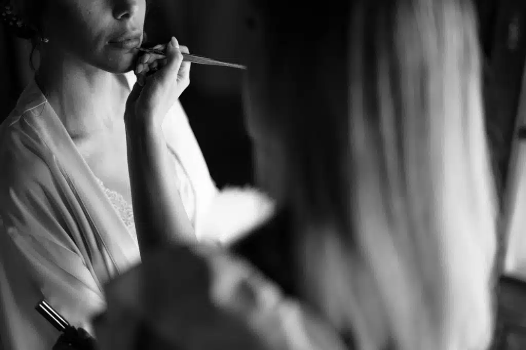 Dentista donna che applica trucco con pinceau, immagine elegante e professionale di servizi di bellezza e make-up.