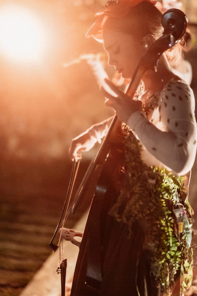 Stringa di testo 2: musica dal vivo durante evento matrimonio, performer che suona il violoncello con atmosfera romantica e raffinata.