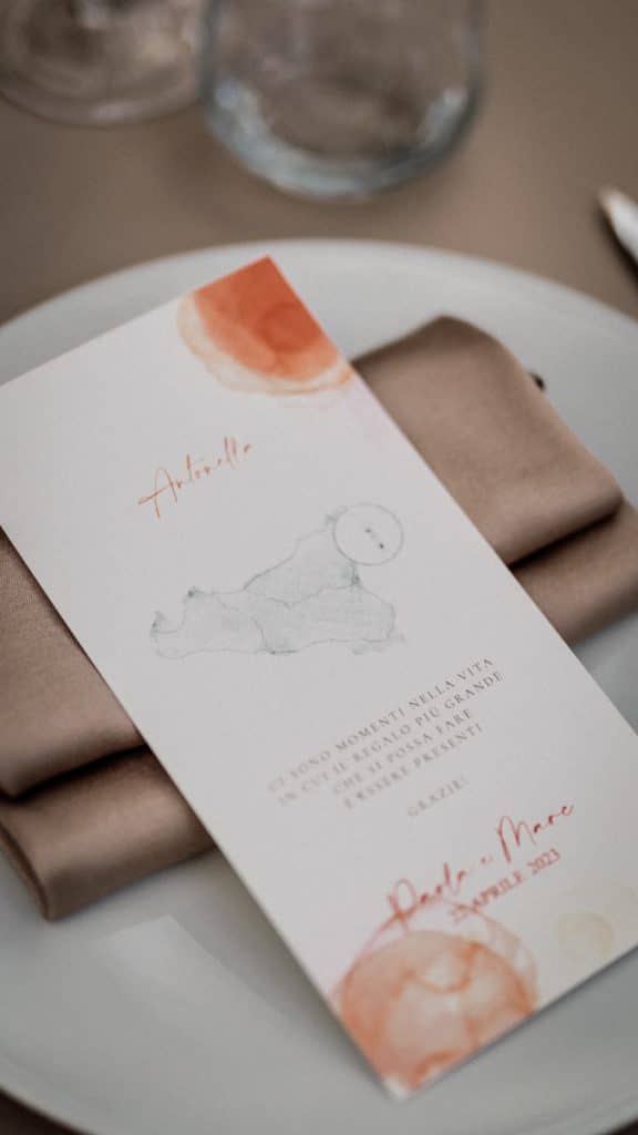 Menù di nozze elegante con disegni artistici e dettagli in tonalità calde, perfetto per matrimoni di lusso in Italia.