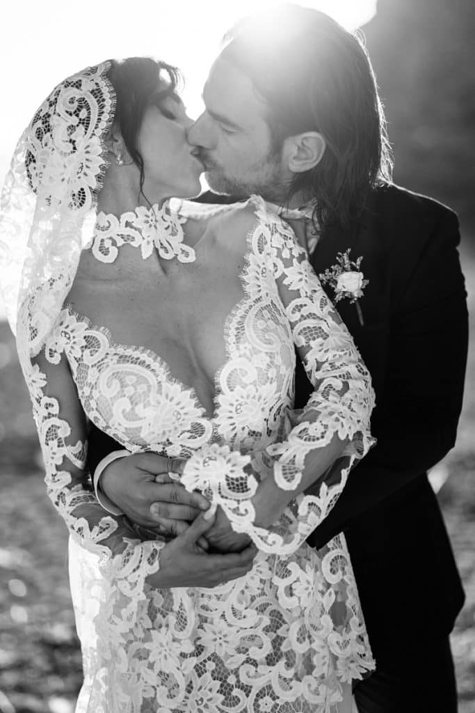 Apparegio di coppia di sposi innamorati, matrimonio con abito da sposa in pizzo e smoking, servizio fotografico di matrimonio elegante, ChiaraB Events Wedding Planner, eventi nuziali di lusso, pianificazione matrimoni Italia.
