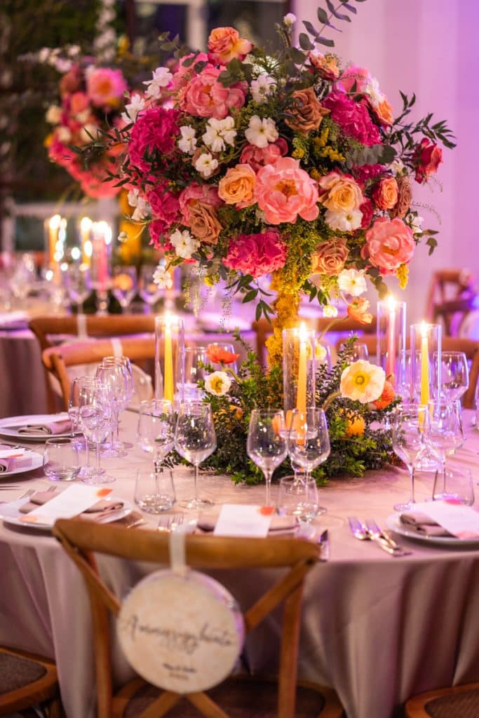 Fioritura centrale con bouquet di rose, peonie e fiori primaverili per eventi nuziali eleganti e raffinati.