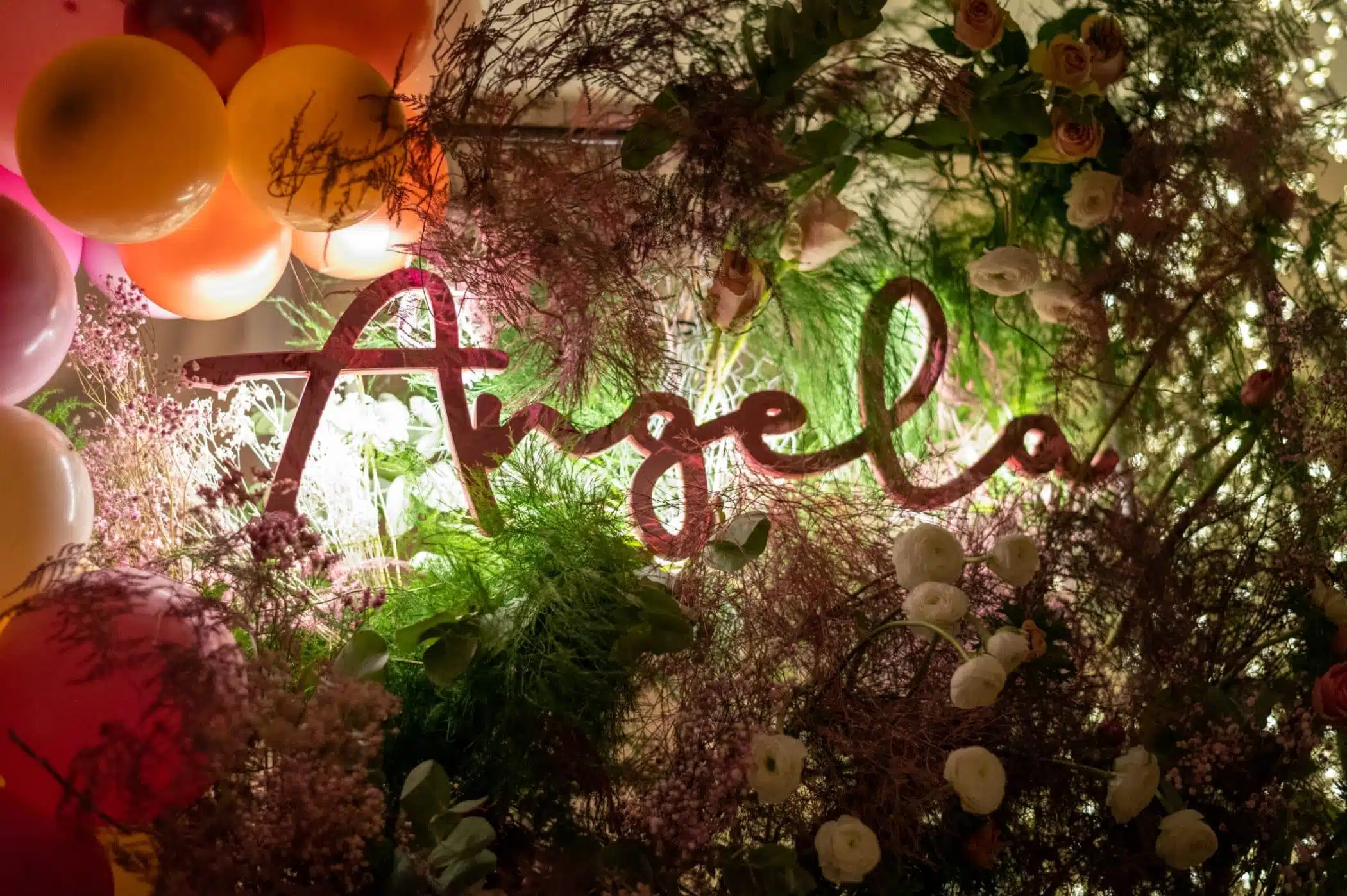Attraente decorazione floreale con luci e palloncini per matrimonio, con scritta "love" illuminata, ideale per wedding planner e eventi romantici.