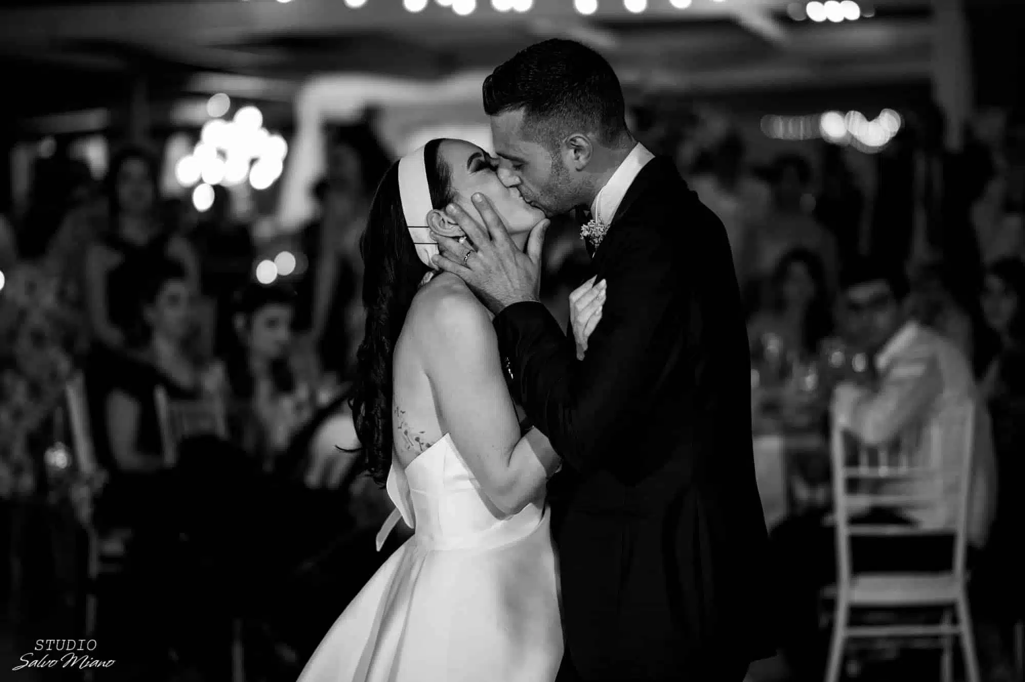 Bacio tra coppia di sposi durante il matrimonio, servizio wedding planner, eventi di matrimonio eleganti, ChiaraB Events wedding planner, cerimonia intima e romantica.