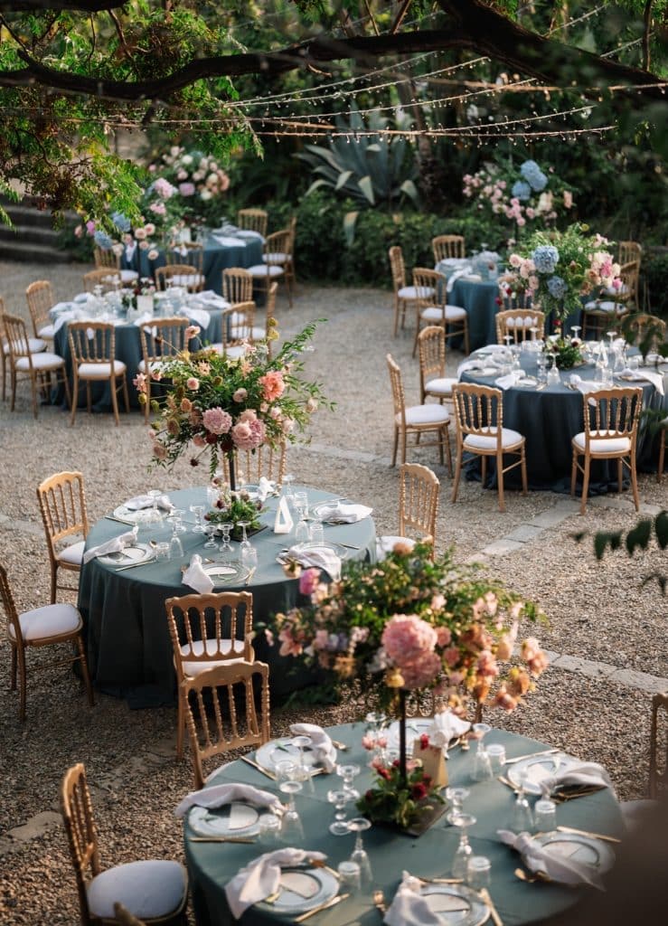 Elegant mise en place per matrimoni, decorazioni floreali di lusso e atmosfera romantica in un giardino esterno. Servizi di wedding planning professionale per eventi esclusivi.