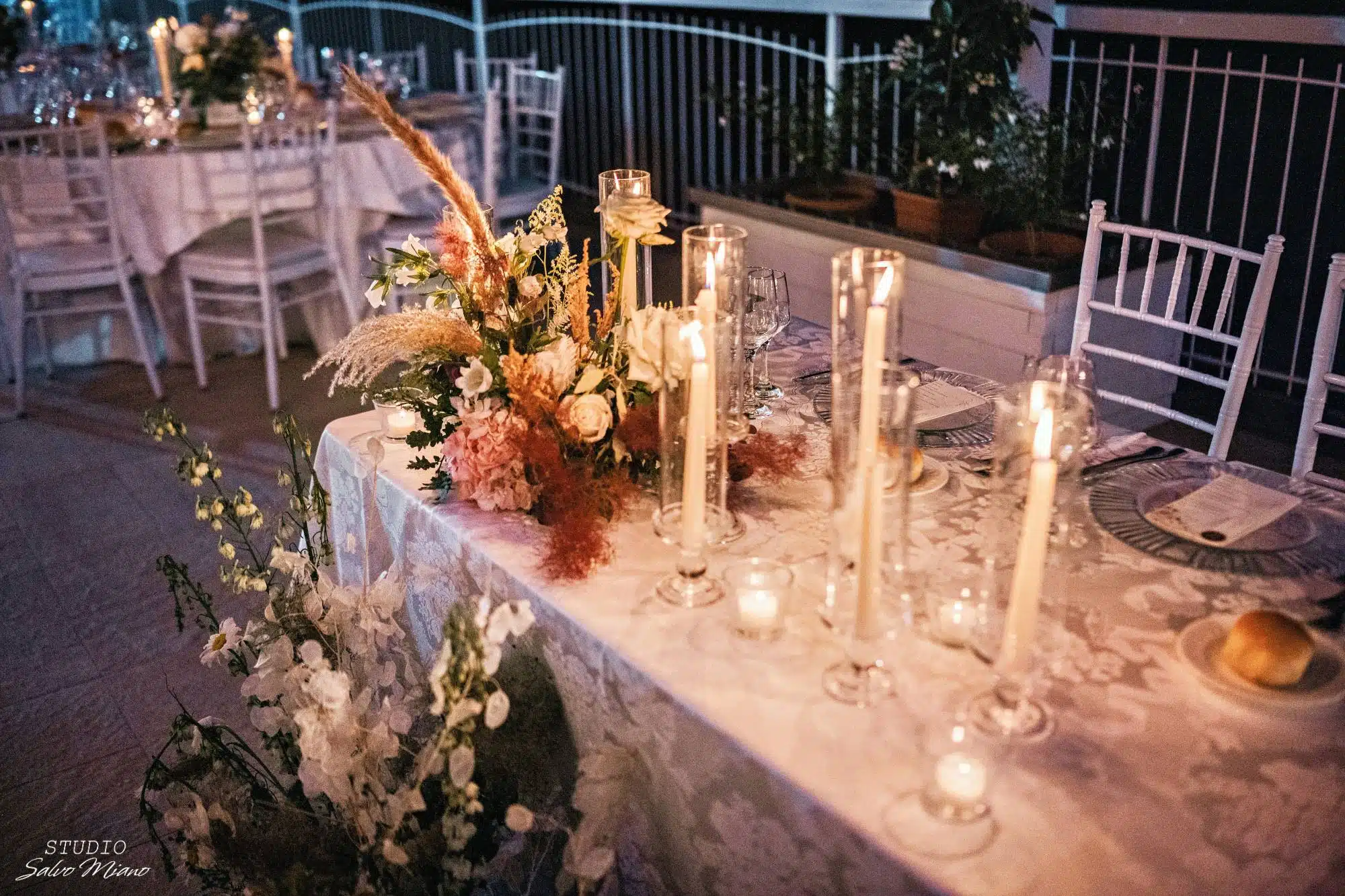 Elegant wedding table decor con candela e fiori, perfetta per matrimoni romantici e sofisticati. Servizi di organizzazione e wedding planner professionale by ChiaraB Events.