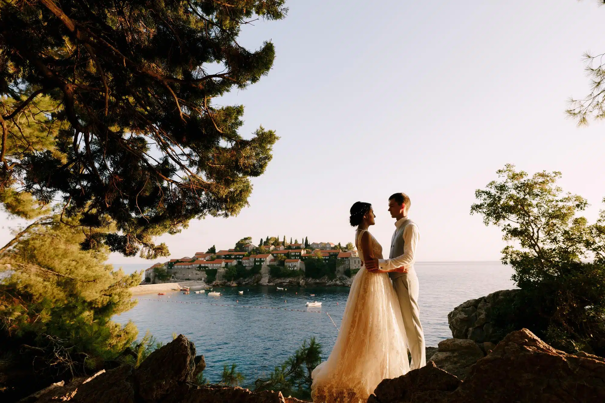 Novias en el acantilado junto al mar con panorama de la isla, evento de boda, organización de eventos, ChiaraB Events organizadora de bodas, destinos de lujo, planificación de bodas, lugar romántico Italia, servicio de bodas de alta calidad.