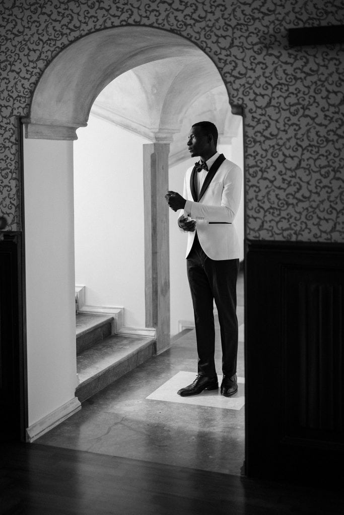 Elegante uomo in abito da sera bianco e nero, in un ambiente raffinato, pronto per un matrimonio o evento speciale, rappresenta il servizio di wedding planning di ChiaraB Events.