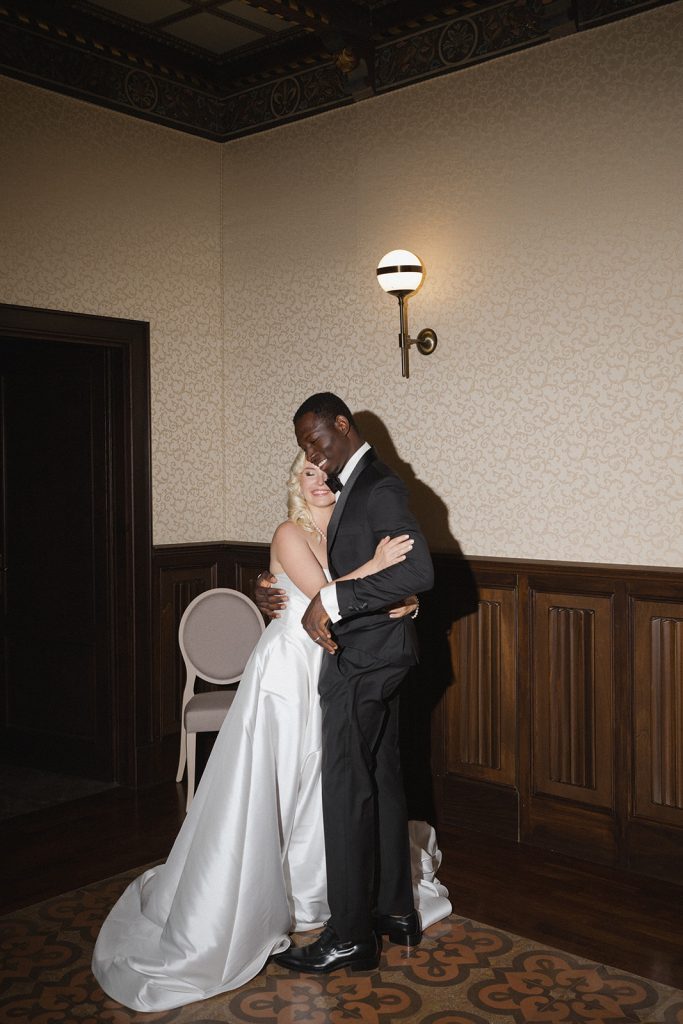 Un matrimonio elegante con sposa in abito bianco e sposo in completo nero che si abbracciano in un ambiente classico e raffinato, perfetto per un matrimonio organizzato da ChiaraB Events Wedding Plann.