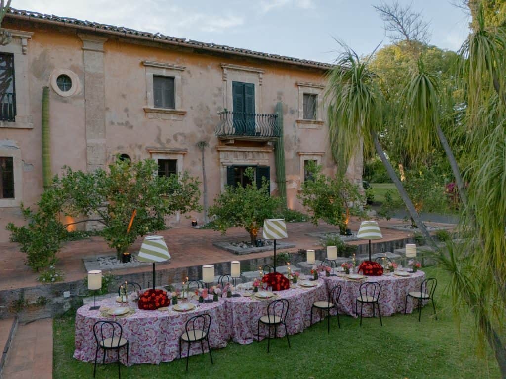 Outdoor wedding table with floral decorations and soft lights in a historic garden, ideal for elegant and romantic events organized by ChiaraB Events Wedding Planner.