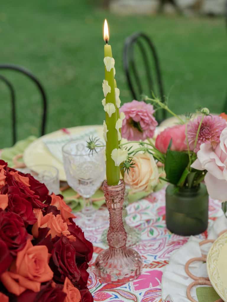 Decorative green candle with white flowers on an outdoor table, perfect for elegant events and weddings, created by ChiaraB Events Wedding Planner.
