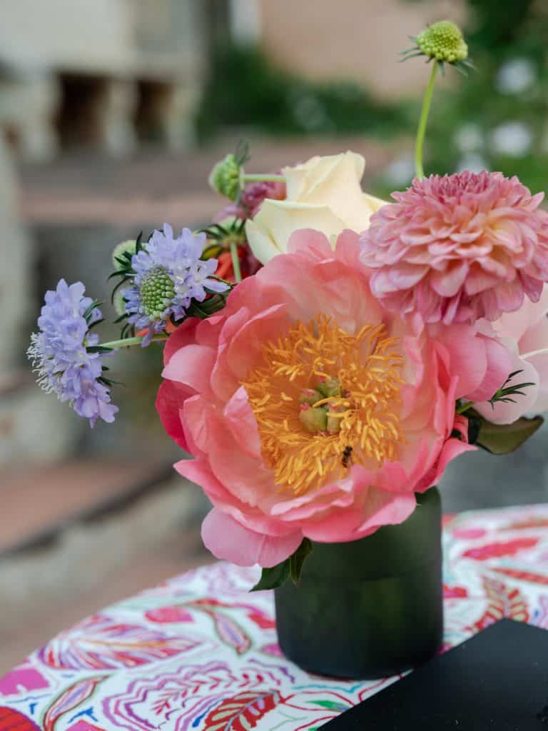 Bloom of colorful flowers in a black vase, elegant decoration for weddings and events, with a natural background and refined atmosphere, perfect for wedding planner ChiaraB Events.