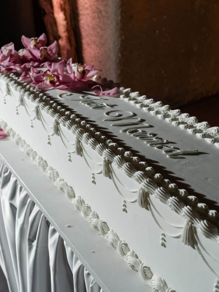 Elegant wedding cake decorated with pink orchid flowers and refined details, perfect for a romantic and sophisticated wedding.