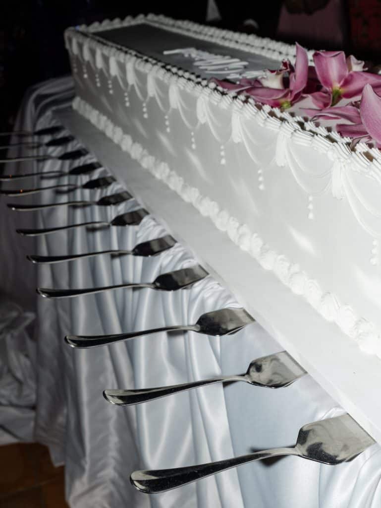 Elegant white wedding cake decorated with rose petals, perfect for refined weddings, set up by ChiaraB Events Wedding Planner, with design details and sophisticated style.