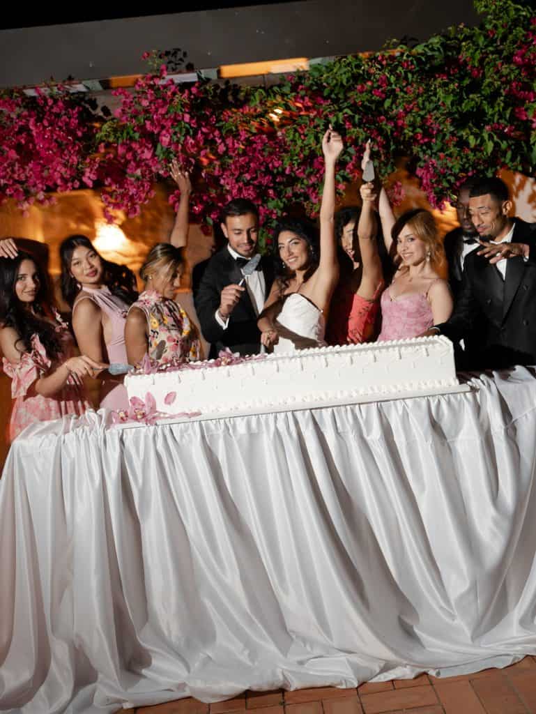 Bride and groom's table with friends and relatives, floral decorations and festive atmosphere, professional wedding planning service.