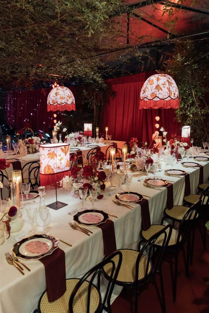 Elegante tavola per matrimonio all'aperto decorata con fiori, candele e luci soffuse, creata da ChiaraB Events Wedding Planner per un evento raffinato e indimenticabile.