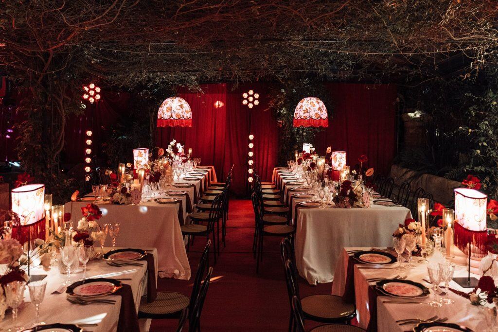 Elegante allestimento di matrimonio con tavoli decorati, luci soffuse e fiori raffinati, ideale per eventi romantici e sofisticati, perfetto per wedding planner e organizzatori di matrimoni.