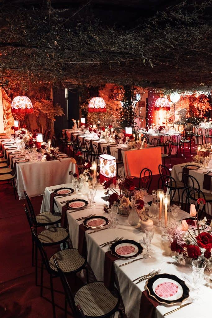Allestimento elegante di matrimonio con tavoli decorati, luci soffuse e fiori freschi, perfetto per eventi romantici e sofisticati organizzati da ChiaraB Events Wedding Planner.