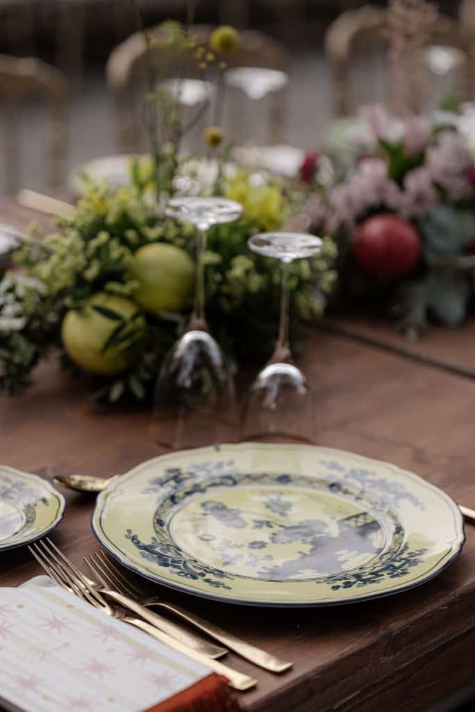 Tavola elegante con piatti in porcellana blu e bianca, bicchieri e decorazioni floreali per matrimonio, allestimento raffinato per evento nuziale.