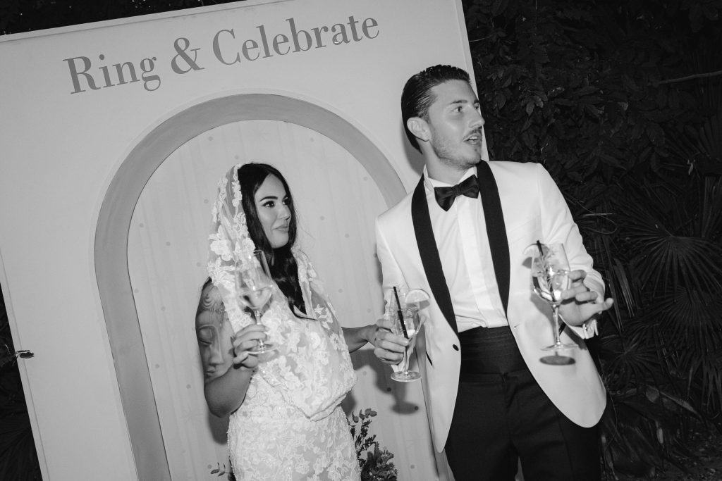 Elegante coppia di sposi che brinda durante il matrimonio, con decorazioni raffinate e atmosfera festosa, perfetta per servizi di wedding planning e organizzazione eventi.