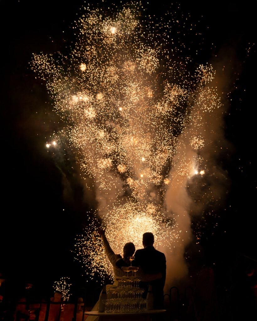 Festa di matrimonio con fuochi d'artificio e fuochi d'artificio sullo sfondo, coppia felice che celebra il loro giorno speciale, organizzato da ChiaraB Events, wedding planner professionista.