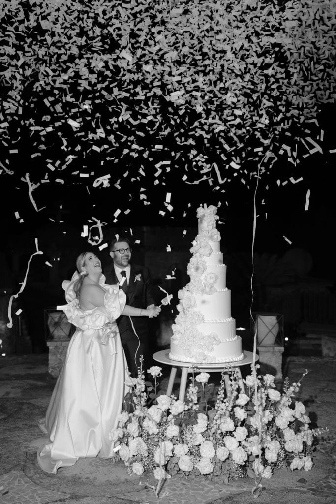 Un matrimonio felice con torta nuziale elegante e decorazioni floreali, celebrato in un'atmosfera romantica e raffinata, perfetta per servizi di wedding planning e organizzazione eventi.
