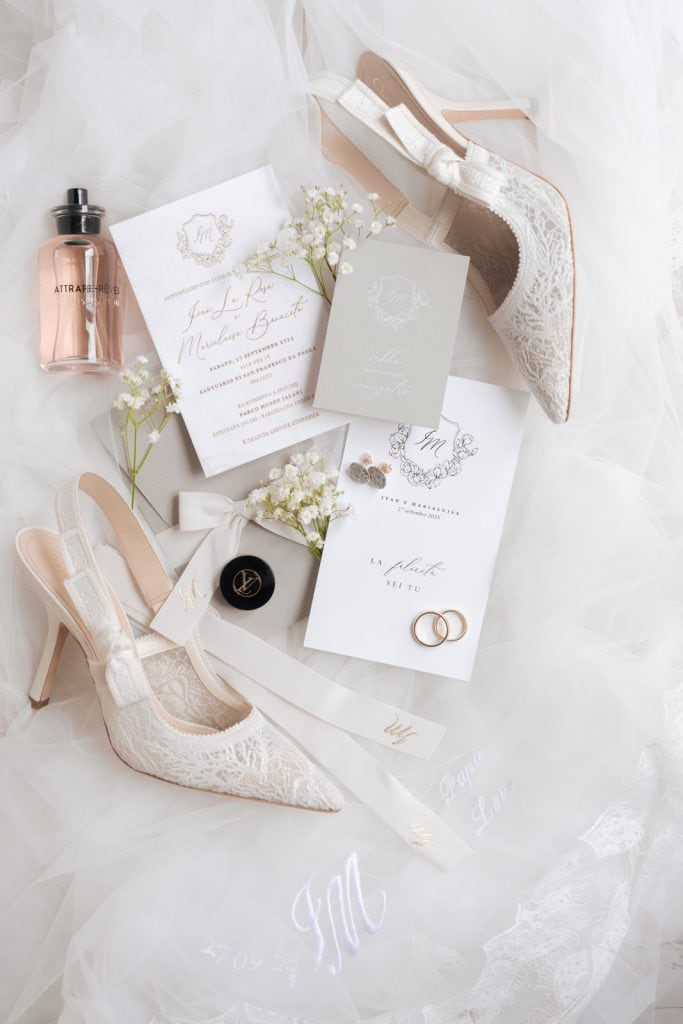 Scarpe da sposa in pizzo con tacco alto, accompagnate da dettagli di matrimonio eleganti e romantici, perfette per un matrimonio da sogno.