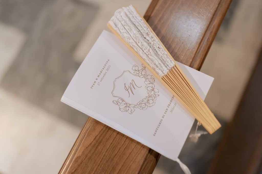 Un profumo di incenso e un mazzo di incenso accanto a un libretto di nozze elegante, simbolo di un matrimonio raffinato e ben pianificato, perfetto per un wedding planner professionale.