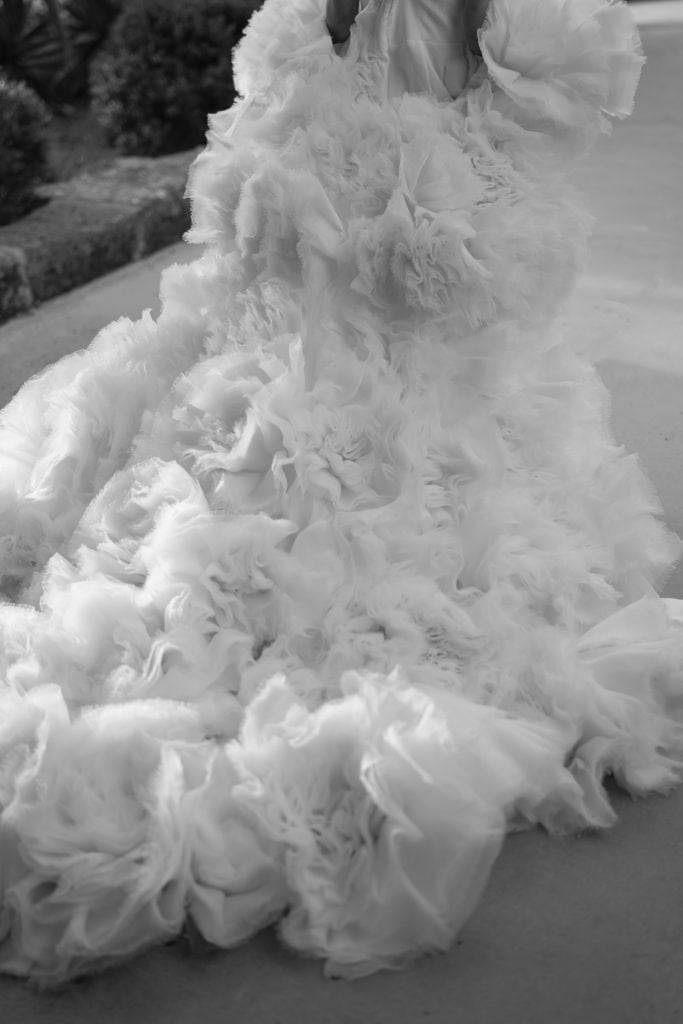Un abito da sposa con dettagli in tulle e pizzo, perfetto per matrimoni eleganti e romantici, fotografato in bianco e nero.