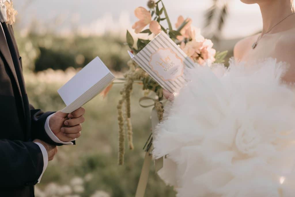 Un altare nuziale elegante con sposi durante la cerimonia di matrimonio all'aperto, con fiori e decorazioni romantiche, rappresenta un servizio di wedding planning professionale.