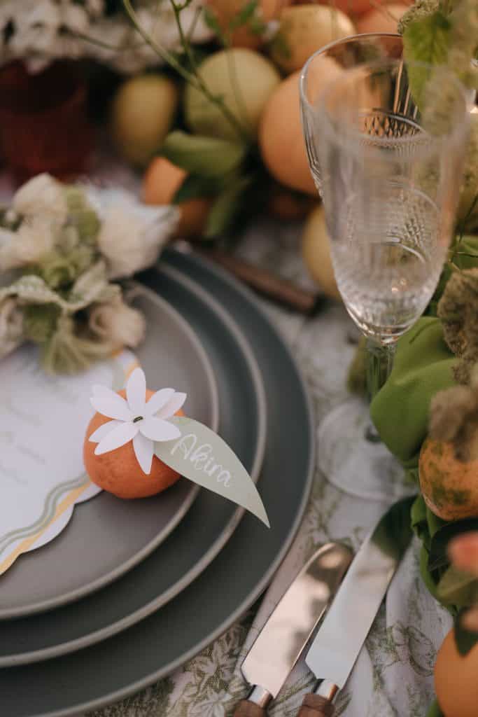 Un bicchiere di cristallo elegante su un tavolo decorato con fiori e frutta, perfetto per un matrimonio o evento speciale organizzato da ChiaraB Events Wedding Planner.