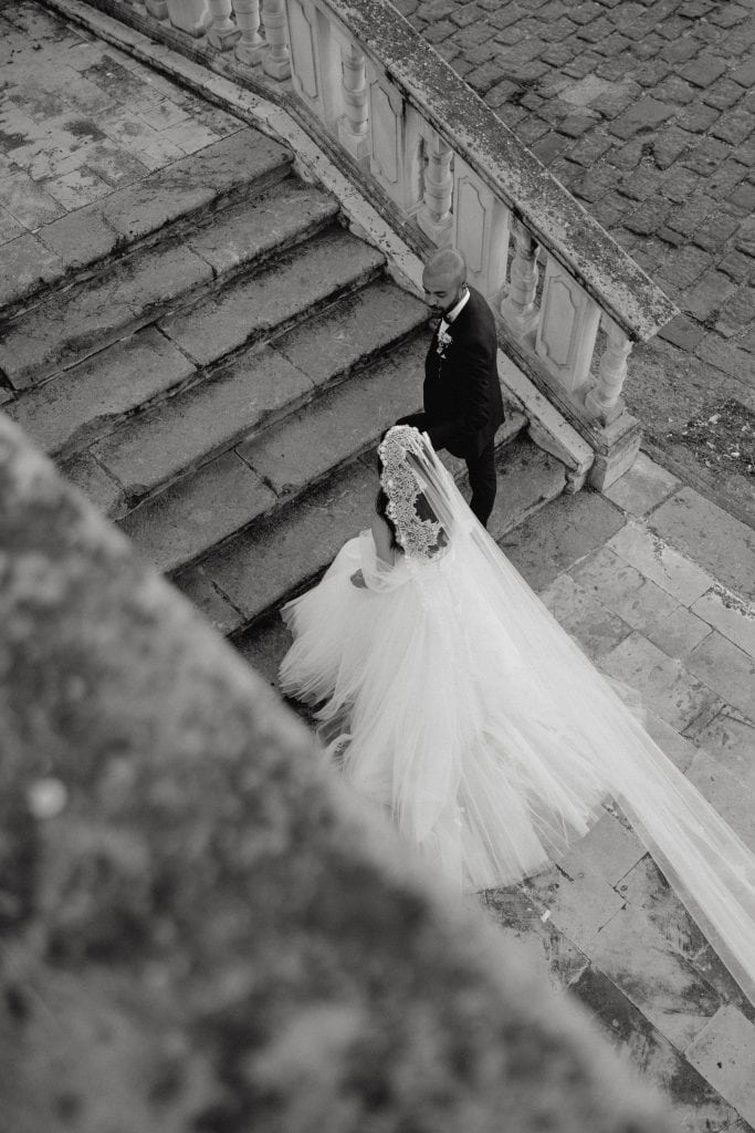 Alberto e Valeria durante il loro matrimonio, con la sposa in abito da sposa e il sposo in completo, in un'ambientazione romantica e suggestiva.