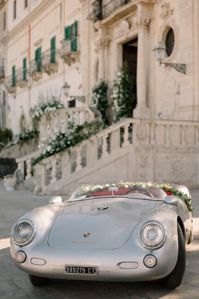 Auto d'epoca Porsche decorata con fiori per il matrimonio di Alberto e Valeria a Venezia, ambientazione storica e romantica.