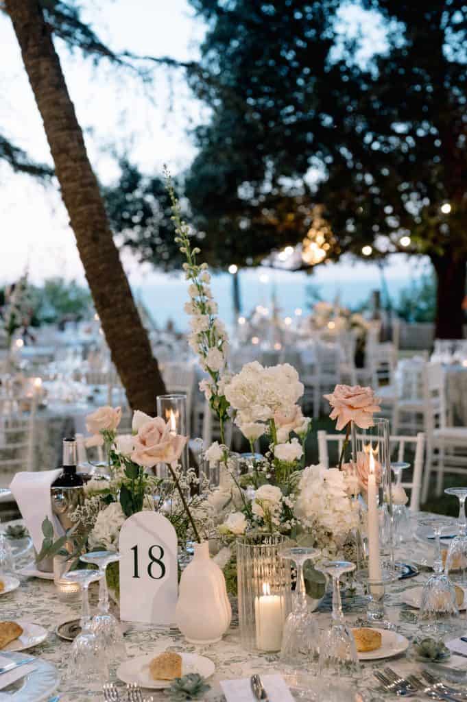 Allestimento matrimonio elegante con decorazioni floreali e luci soffuse in un giardino estivo. Perfetto per un matrimonio romantico e raffinato all'aperto.