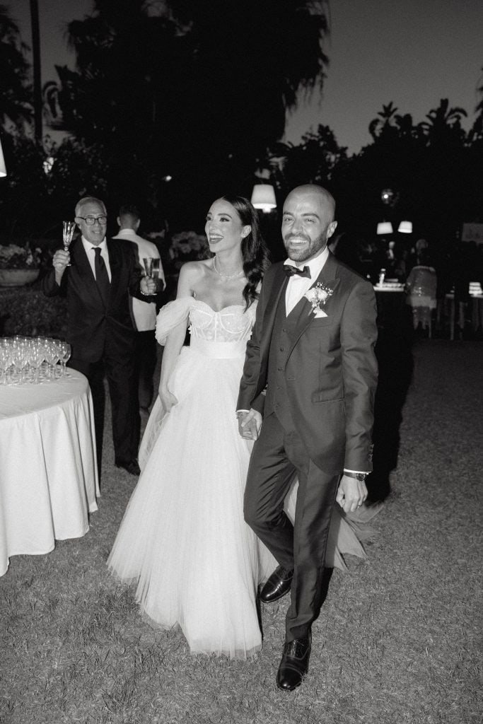 Alberto e Valeria al loro matrimonio, sorridenti e felici, durante il ricevimento all'aperto con atmosfera elegante e romantica, curata da ChiaraB Events Wedding Planner.