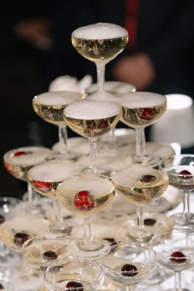 Elegante torre di flute con champagne e ciliegie, perfetta per matrimoni e eventi esclusivi, creata da ChiaraB Events Wedding Planner.