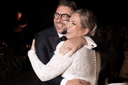 Boldog esküvői pár ölelkezve az esküvőn, romantikus és ünnepi hangulatban.